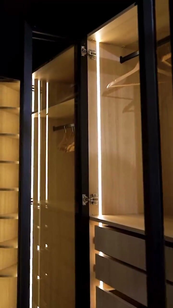 A Pannello wardrobe interior: lit shelves, a hanging rail and soft-close drawers being opened