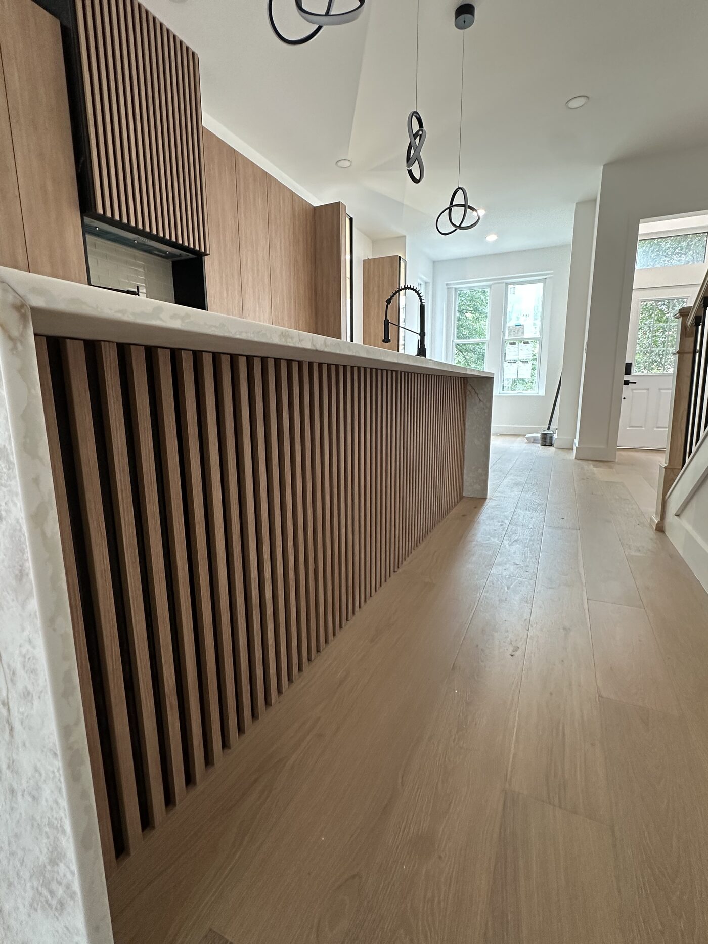 Slat-front island detail. The fluting is machined into the panel, not applied over it.