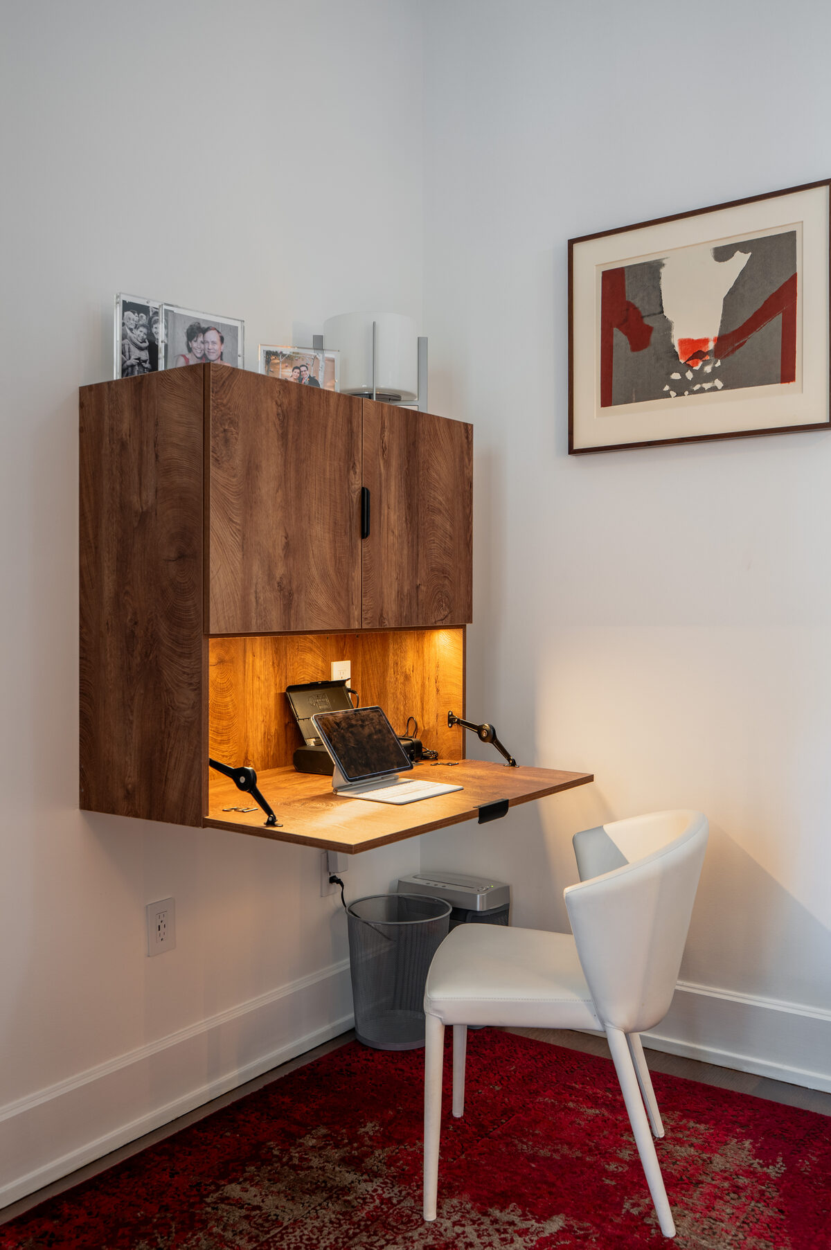 Fold-down desk built into walnut casework, with concealed task lighting.